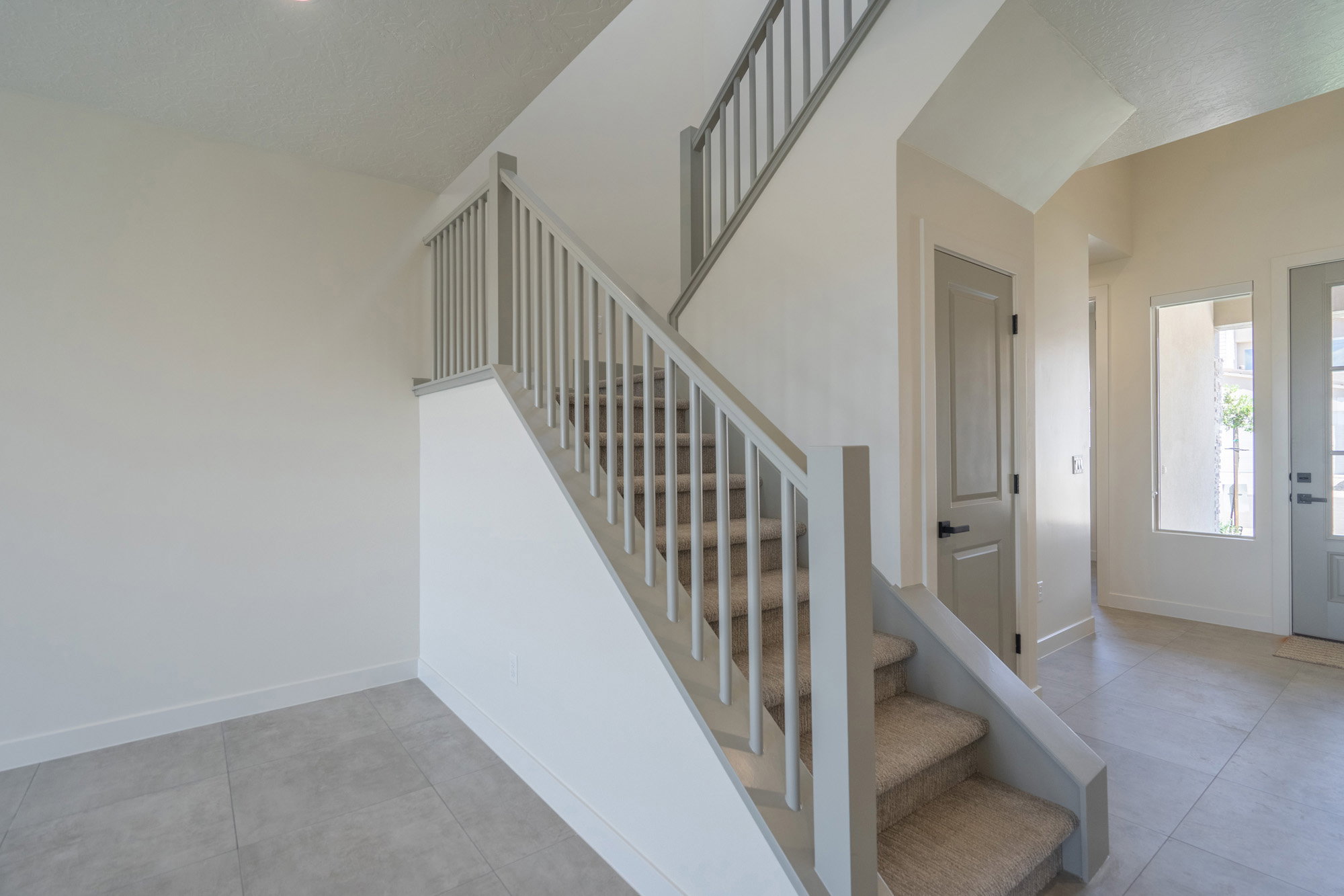 Carpeted staircase featuring a light gray railing
