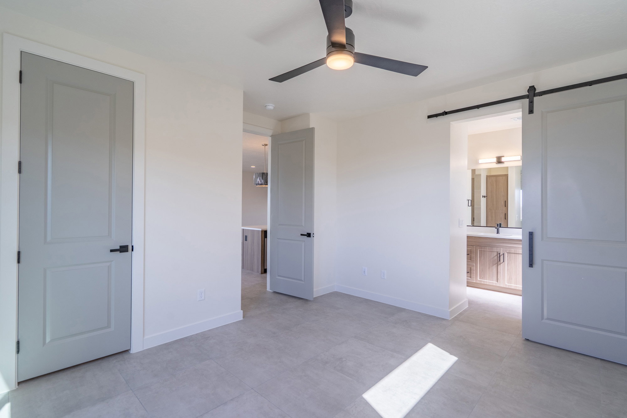 Spacious room featuring light-colored walls and large format tile flooring