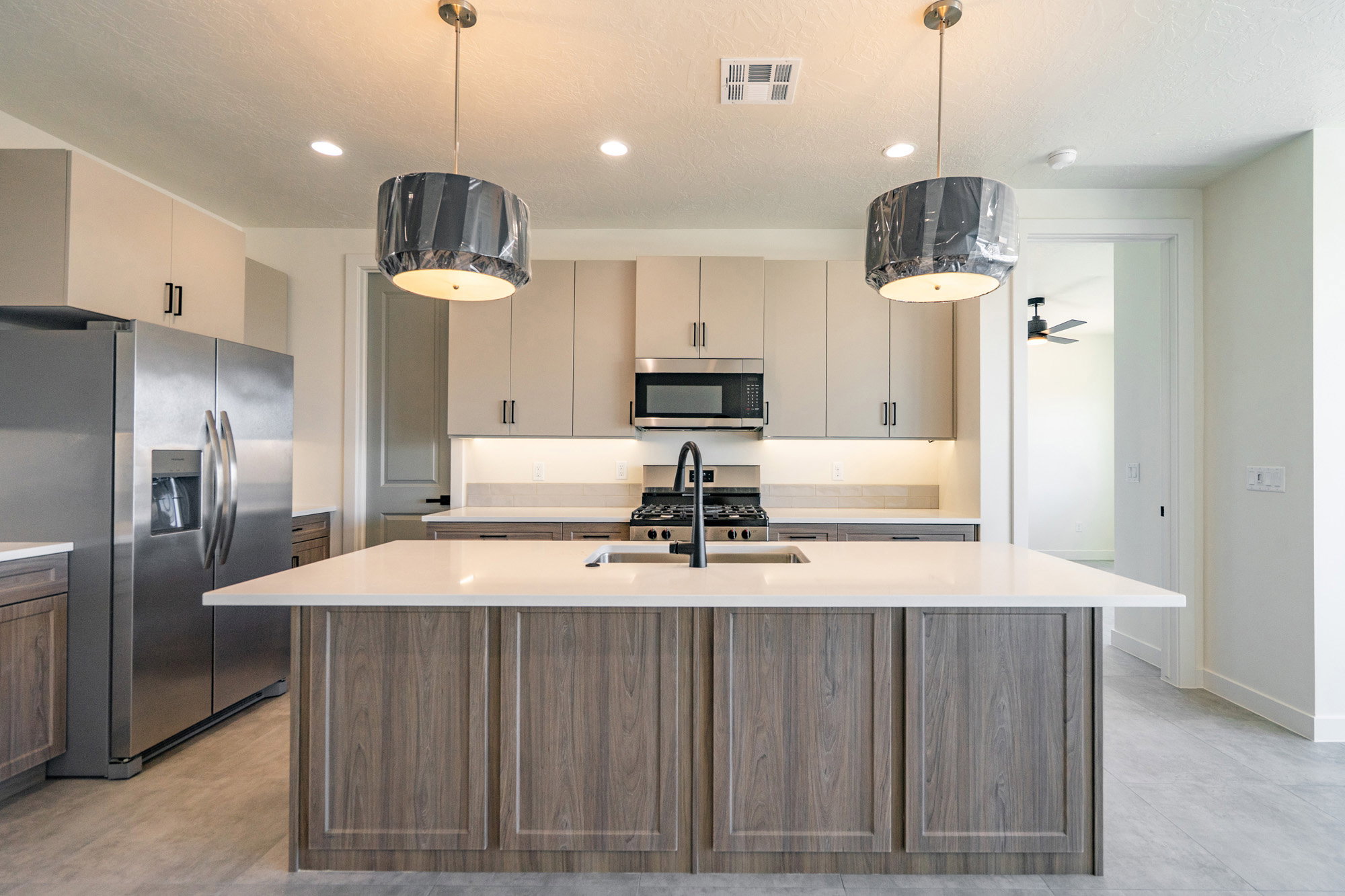Kitchen featuring a central island with a light-toned countertop and wood-finish cabinetry