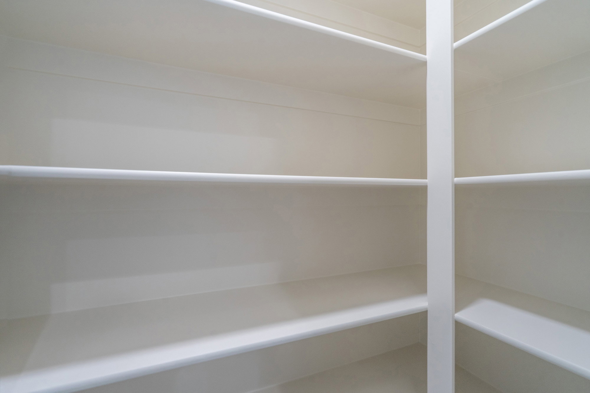 Expansive storage closet featuring multiple tiers of white shelving