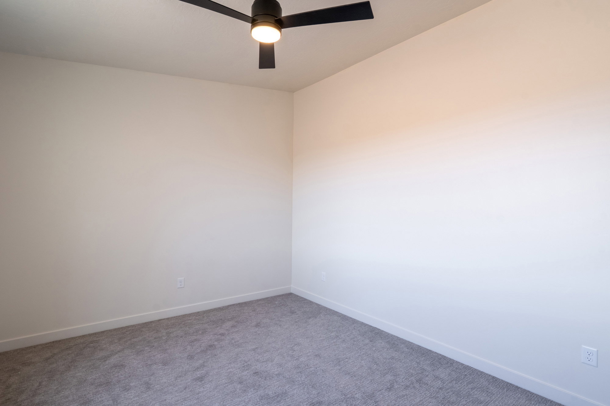 Open interior space featuring light neutral wall paint and gray carpet flooring