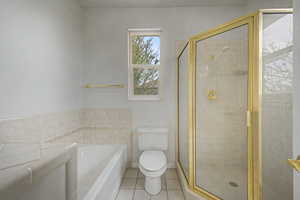 Bathroom featuring a gold-framed glass shower enclosure, a built-in bathtub, and a window