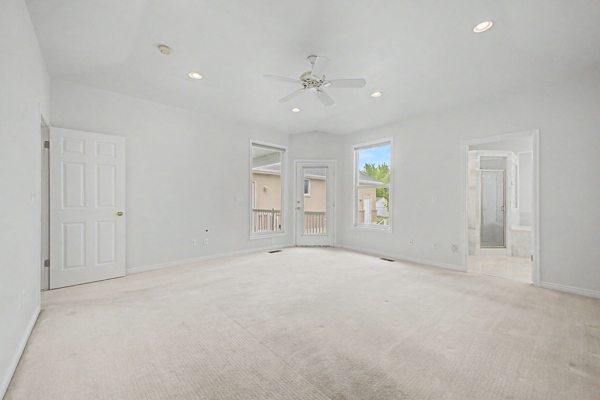 Spacious room featuring vaulted ceilings, recessed lighting, a ceiling fan, and light-toned carpeting