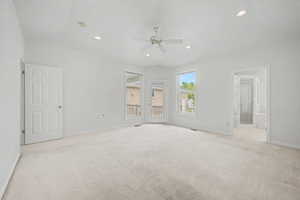 Spacious room featuring vaulted ceilings, recessed lighting, a ceiling fan, and light-toned carpeting