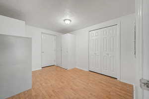 Room featuring wood-finish flooring, a bi-fold closet, and recessed lighting