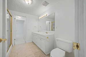 Bathroom featuring a double vanity with white cabinetry, dual sinks, and a large wall-mounted mirror