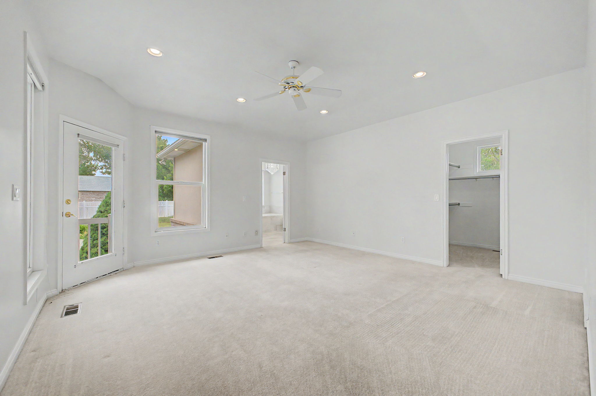 Spacious room with plush carpet flooring, recessed lighting, and a ceiling fan