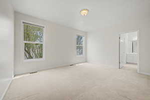 Spacious room featuring neutral carpeting and white walls