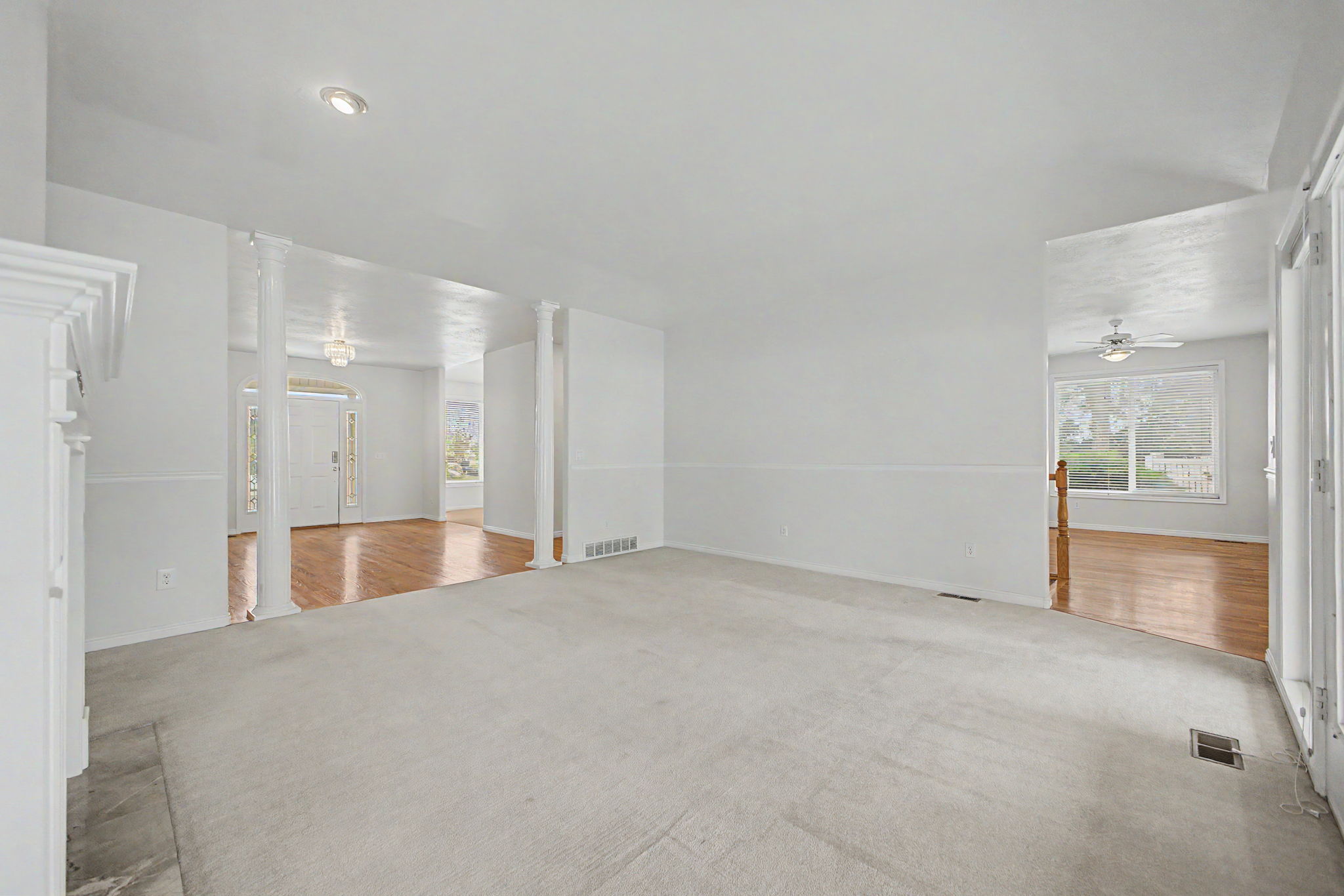 Spacious carpeted room featuring white walls and recessed lighting