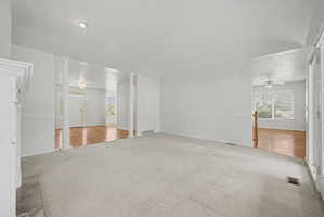 Spacious carpeted room featuring white walls and recessed lighting