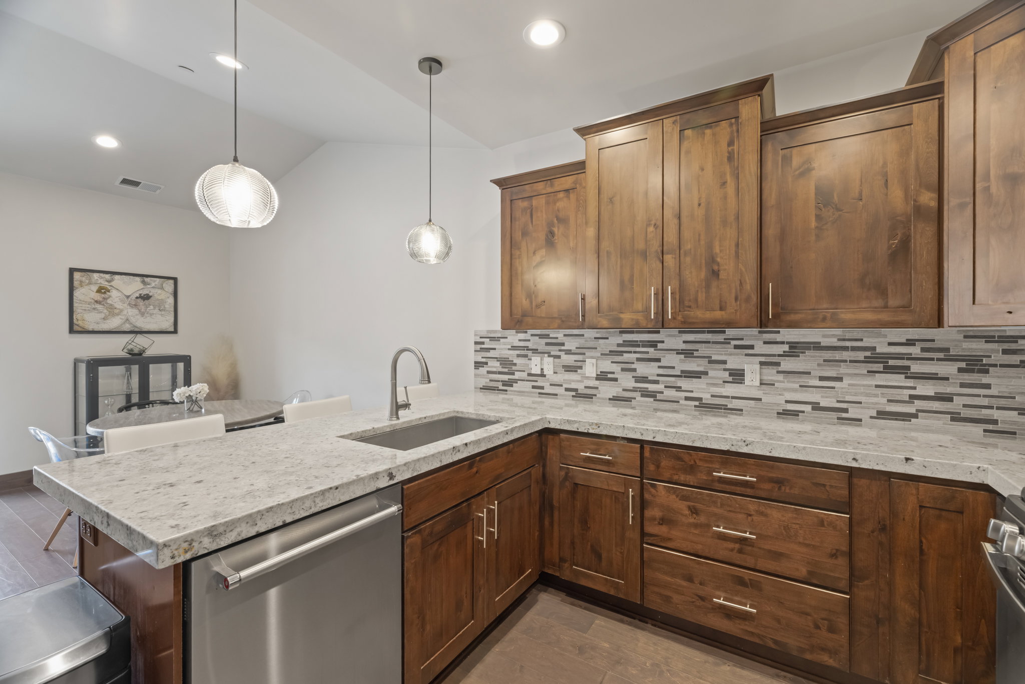 Kitchen featuring wood-finish cabinetry, light-toned countertops, and a mosaic tile backsplash