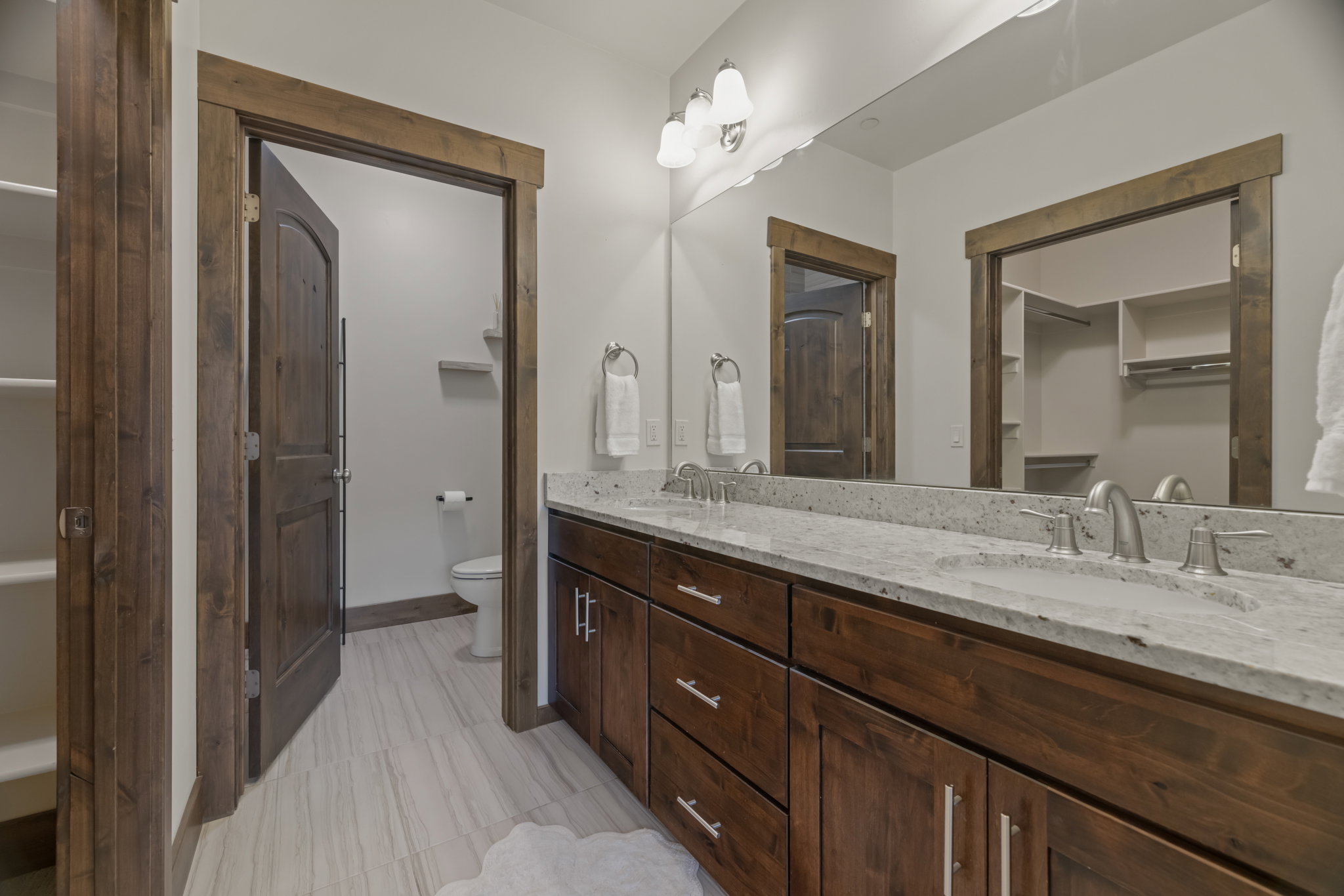 Double vanity with undermount sinks and light-colored stone countertops