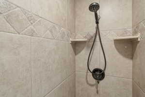 ADU tiled shower surround featuring a decorative accent band