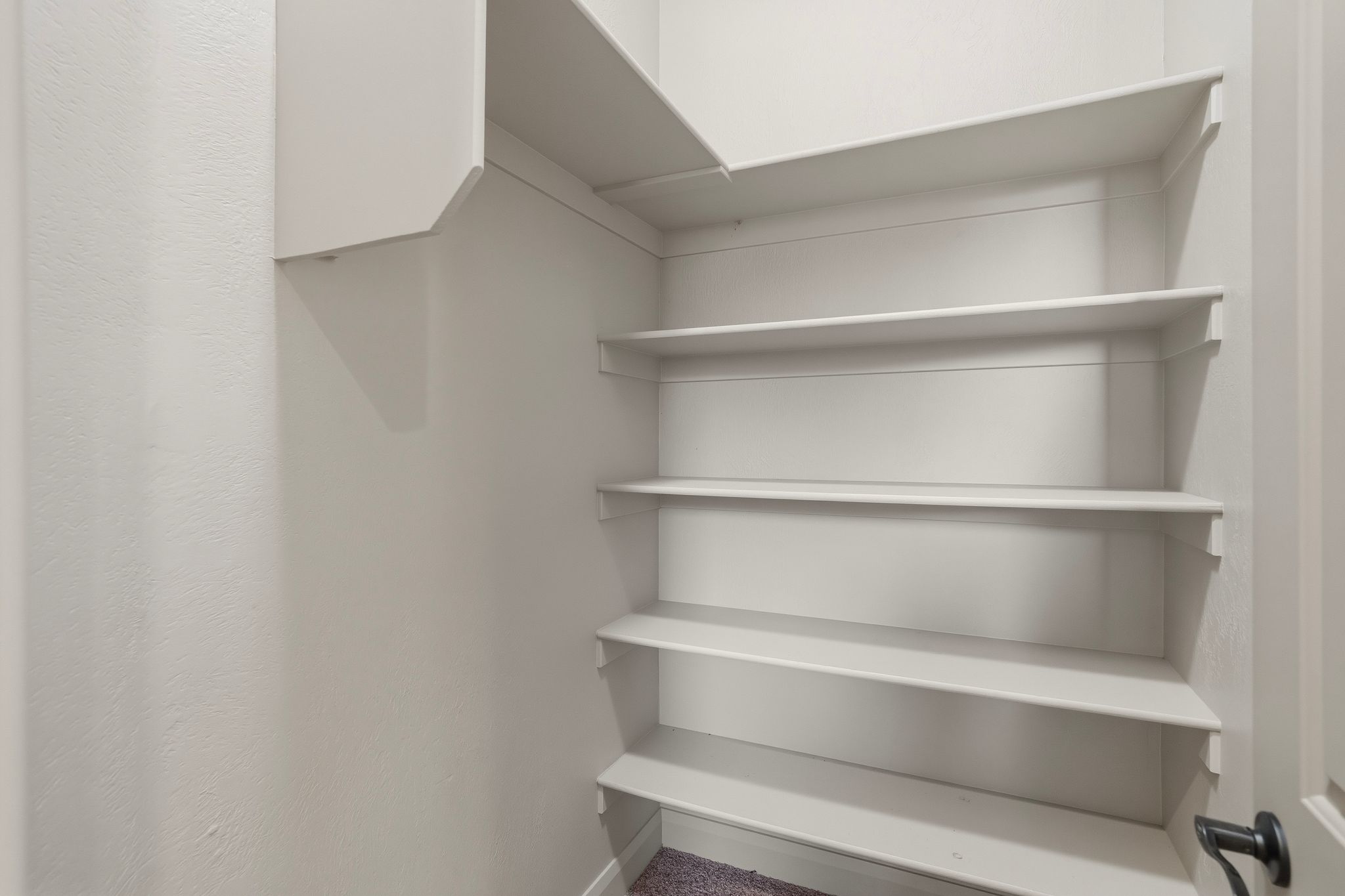 Large linen closet with multiple white shelving units