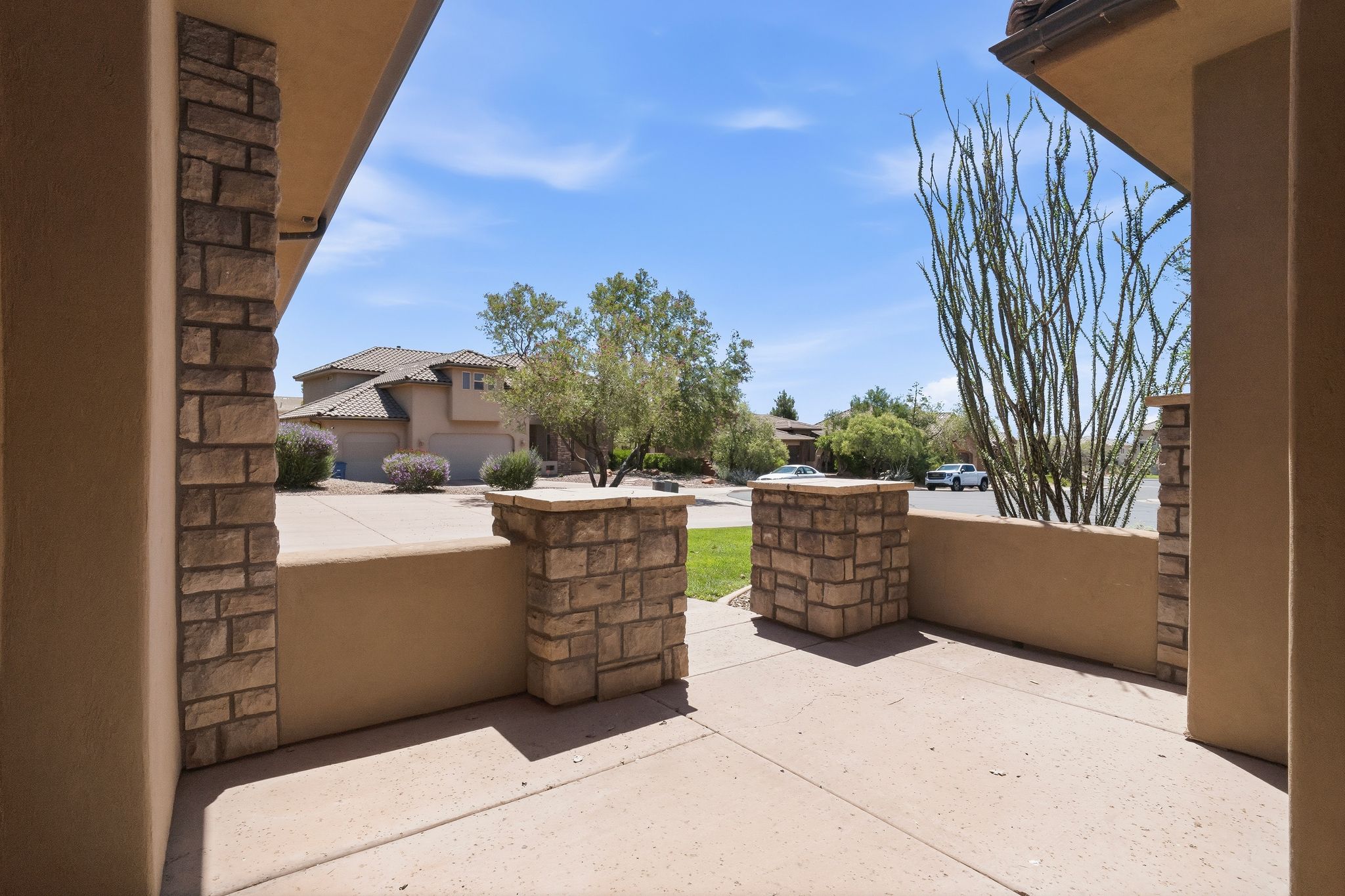 Entryway patio featuring natural stone veneer accents and a stucco finish