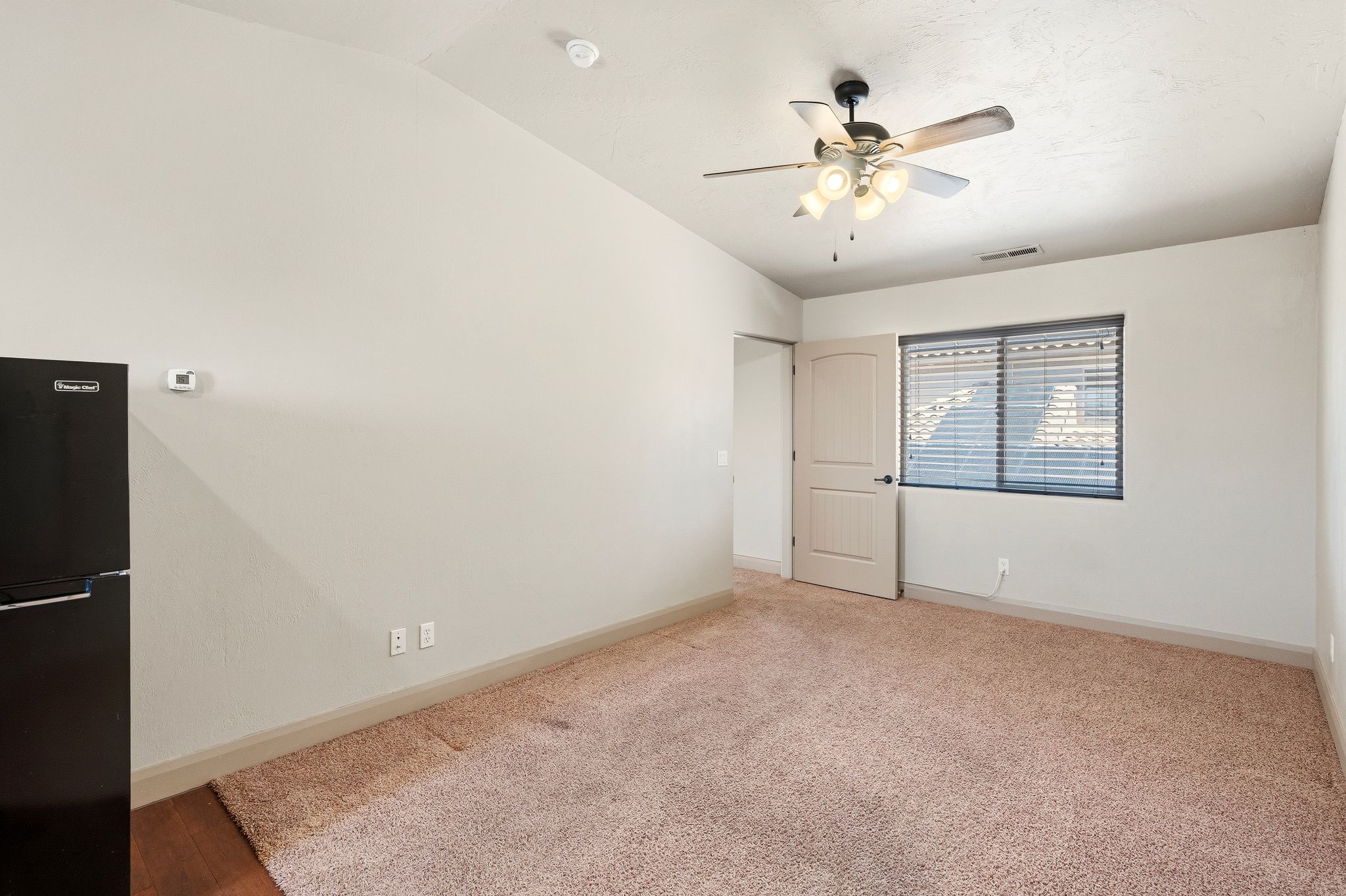 ADU living room, neutral-toned carpeting extends across this room featuring a ceiling fan with integrated lighting