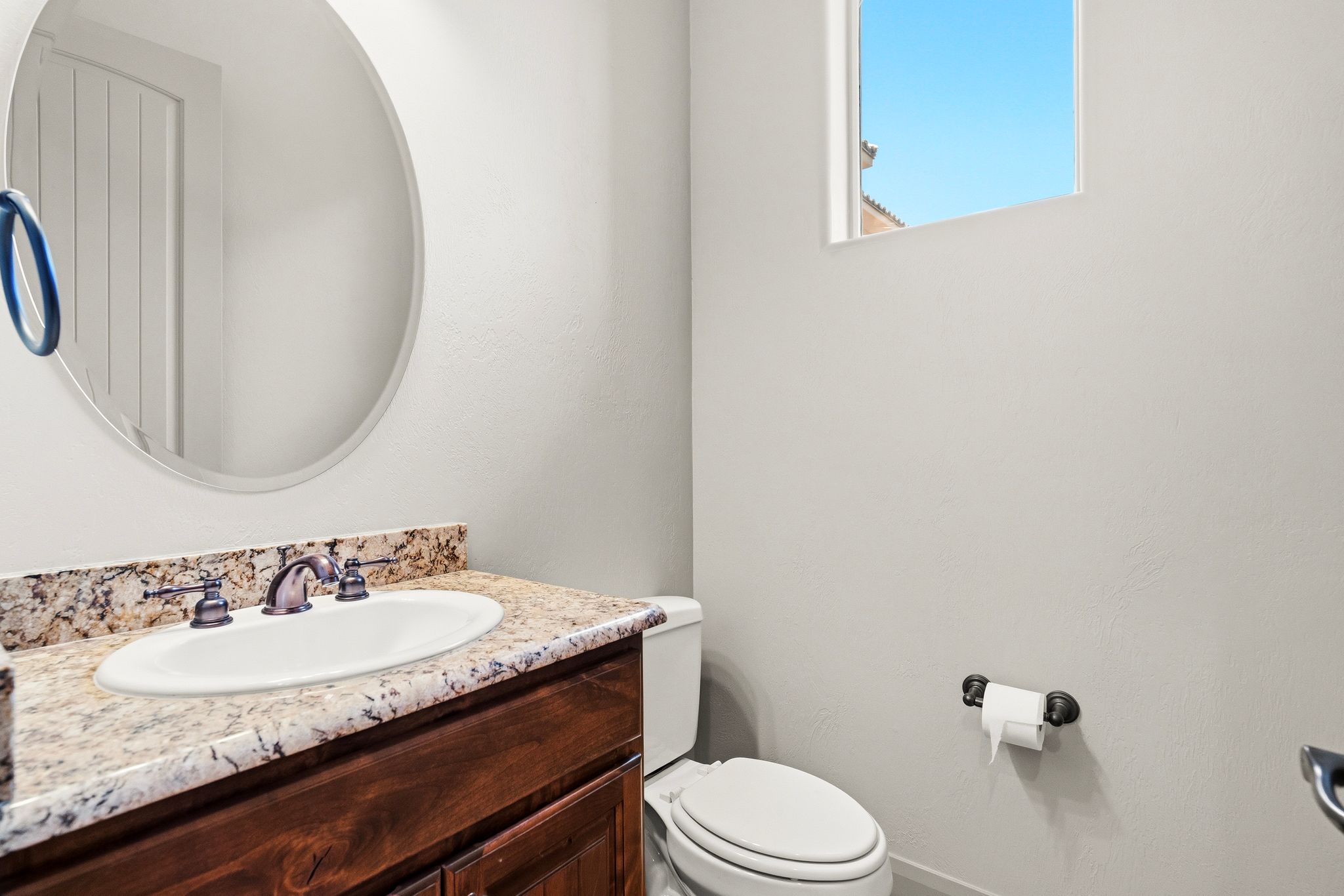 Vanity with a light-toned countertop, integrated sink, and an oil-rubbed bronze faucet