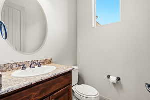 Vanity with a light-toned countertop, integrated sink, and an oil-rubbed bronze faucet