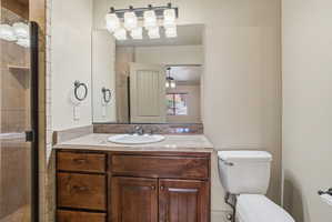 ADU bathroom vanity with a surface-mount sink, dark wood cabinetry, and a stone countertop