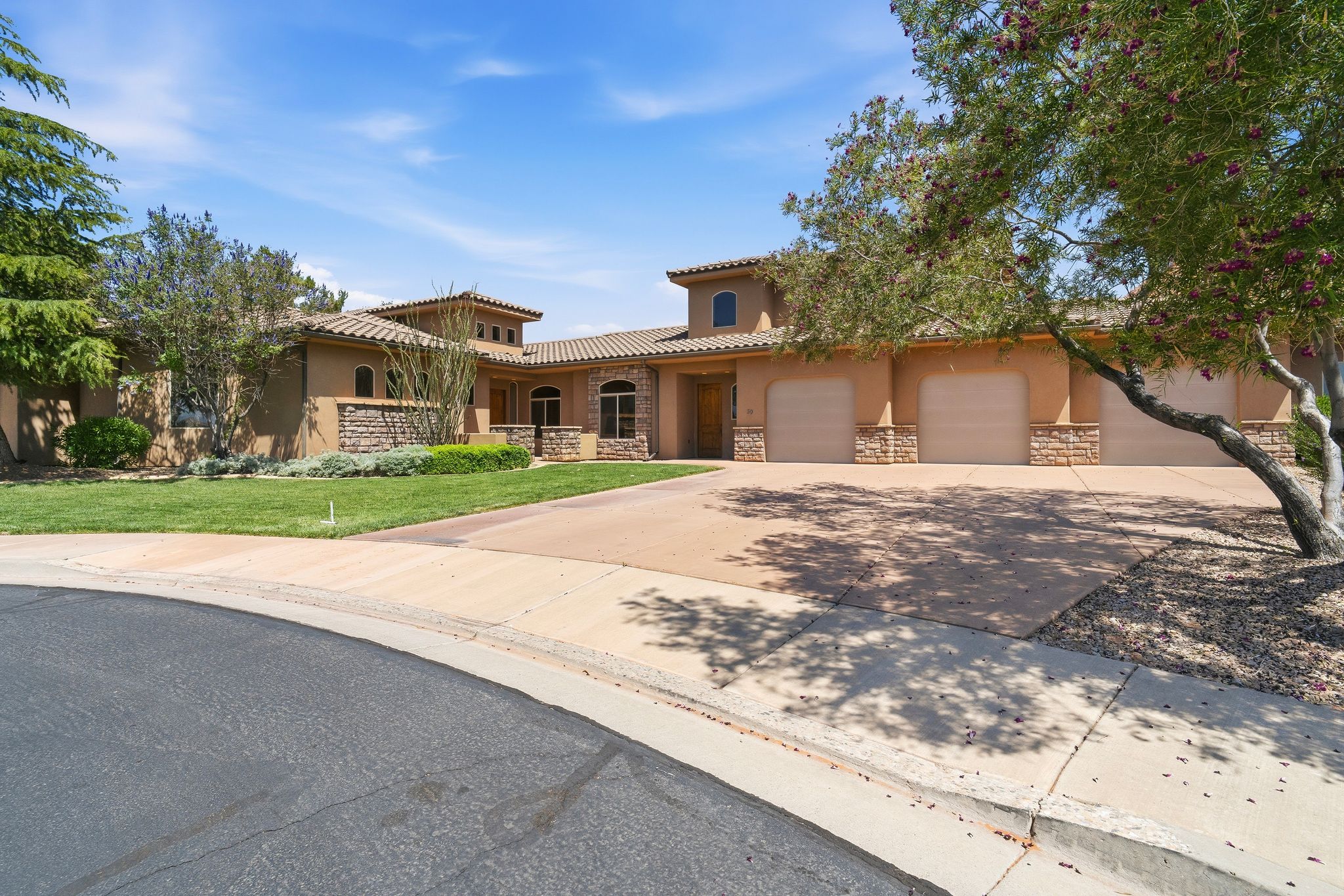 Stucco exterior with stone accents and a terracotta tile roof