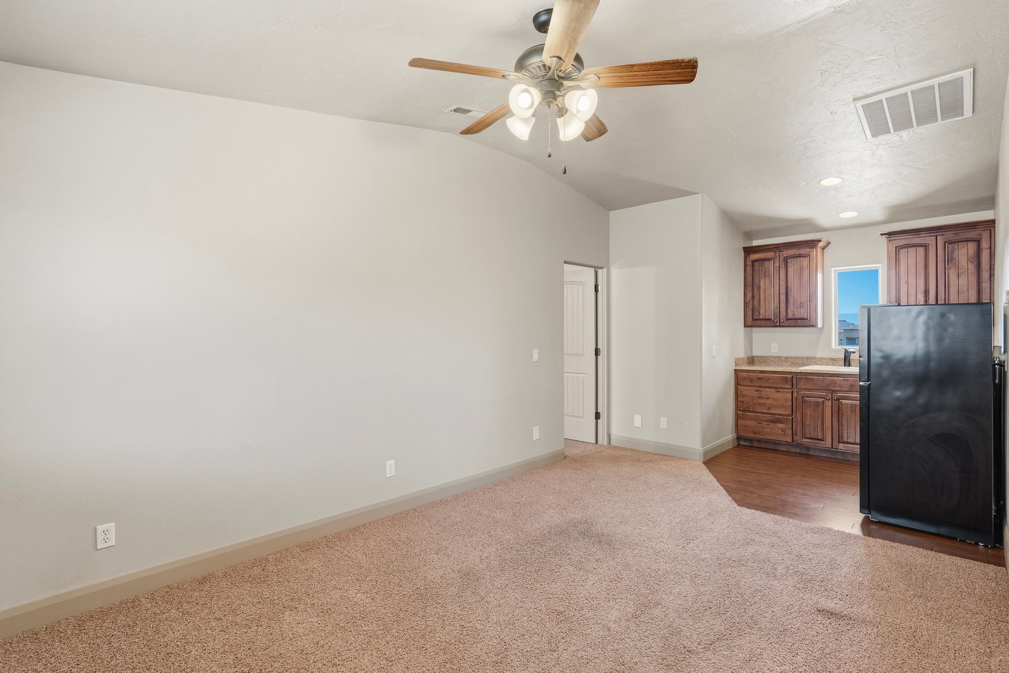 ADU  vaulted ceiling with an overhead fan and light fixture