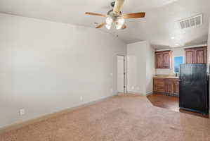 ADU  vaulted ceiling with an overhead fan and light fixture