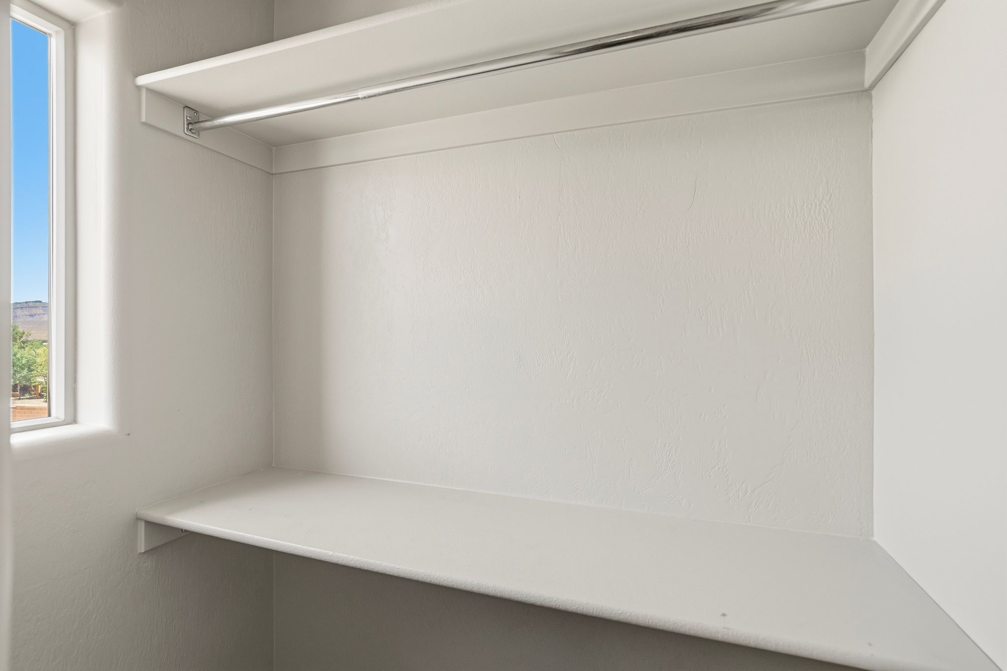 ADU closet with a single window, upper shelf, and lower shelf