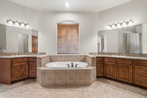 Primary suite bathroom, central soaking tub with tiled surround