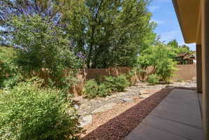 Private backyard featuring a concrete patio, surrounding rock landscaping, and a block fence