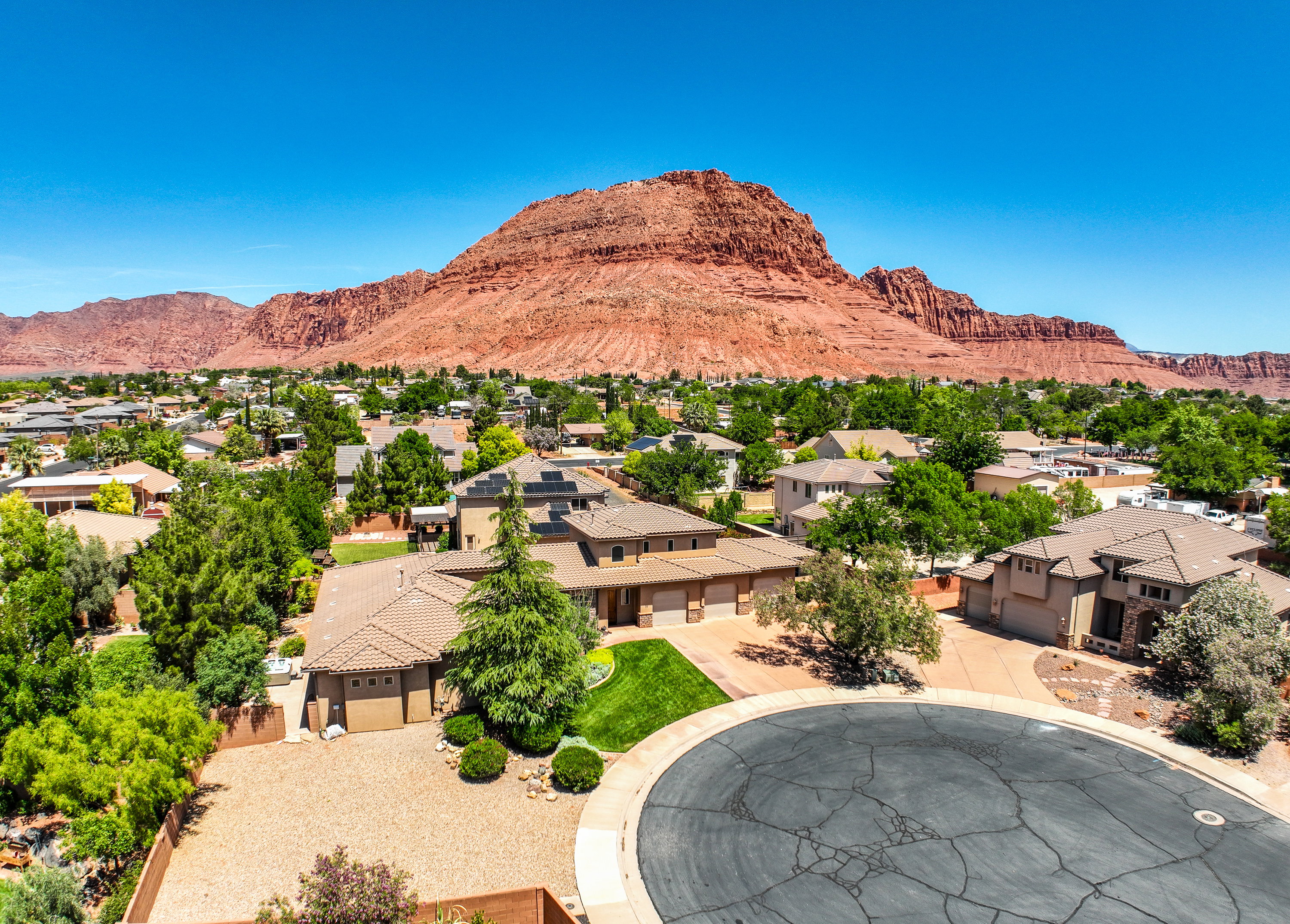 Aerial view of neighborhood setting with red rock mountain backdrop.