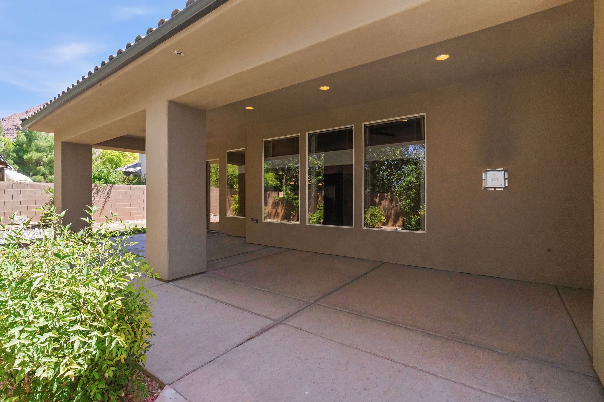 Backyard covered patio featuring recessed lighting and multiple windows