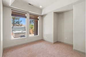 Primary suite, extra room within primary suite. Featuring dual windows with woven wood blinds and recessed lighting.