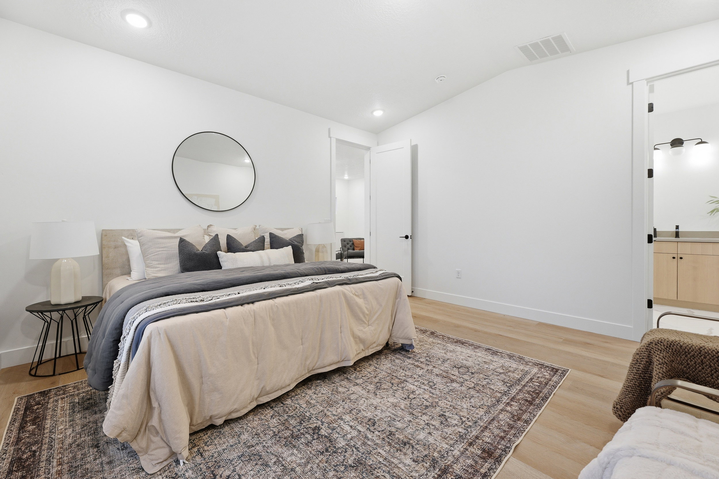 Spacious room featuring light wood-finish flooring, recessed lighting, and a modern sliding barn door