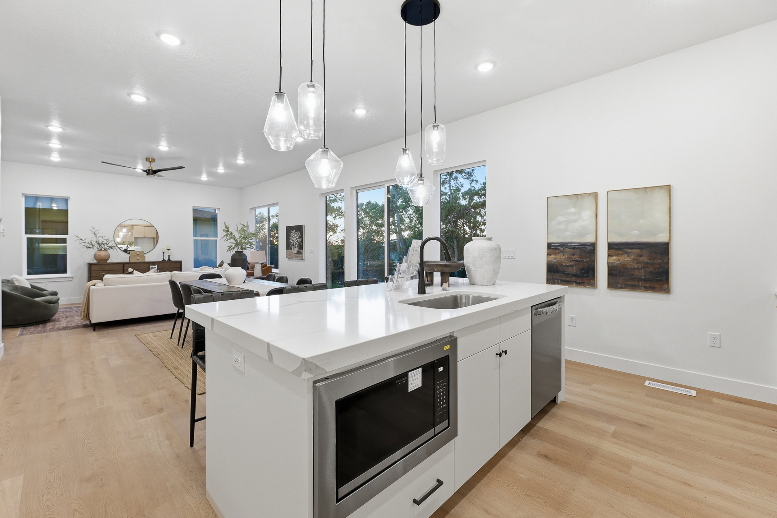 Contemporary kitchen island featuring a waterfall countertop, undermount sink, and integrated microwave