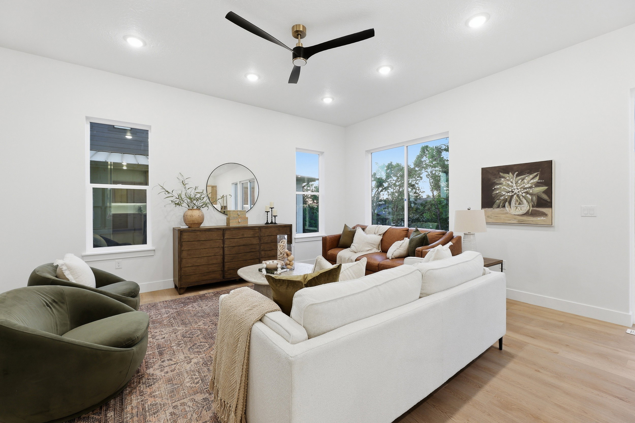 Spacious living area featuring light wood-finish flooring, recessed lighting, and a contemporary ceiling fan