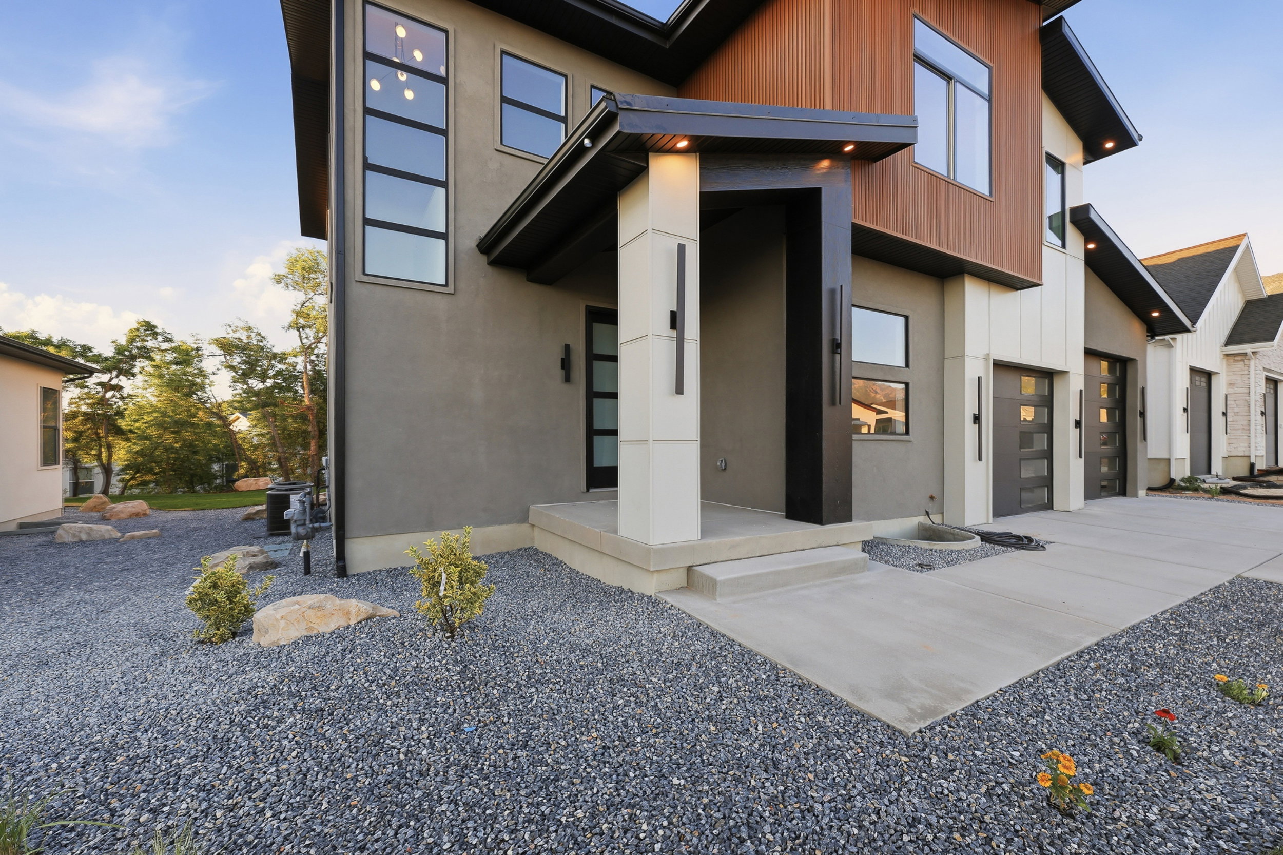 Modern exterior with a neutral stucco finish and warm wood-look siding accents