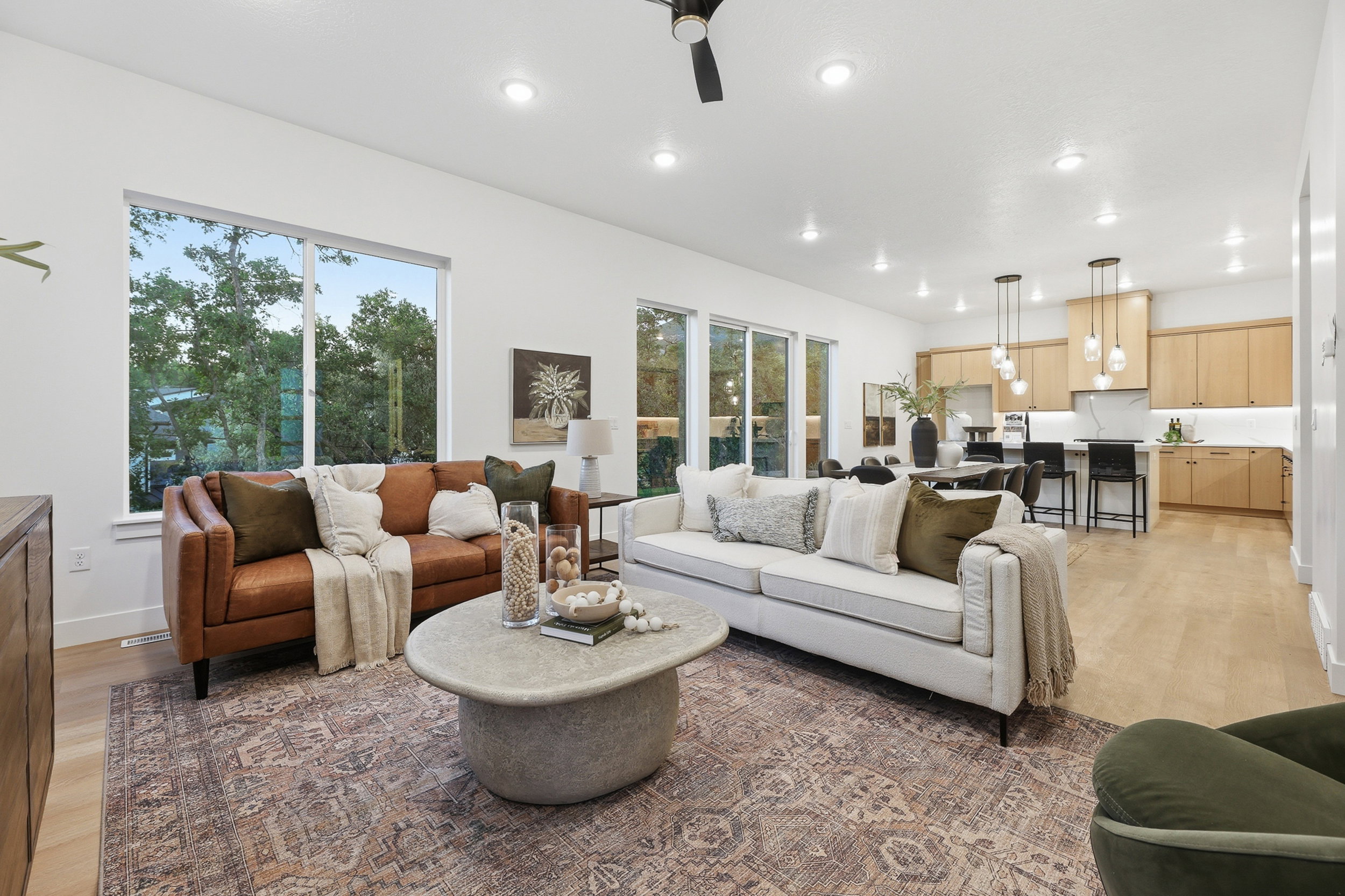 Spacious living area featuring light wood-finish flooring and numerous recessed ceiling lights