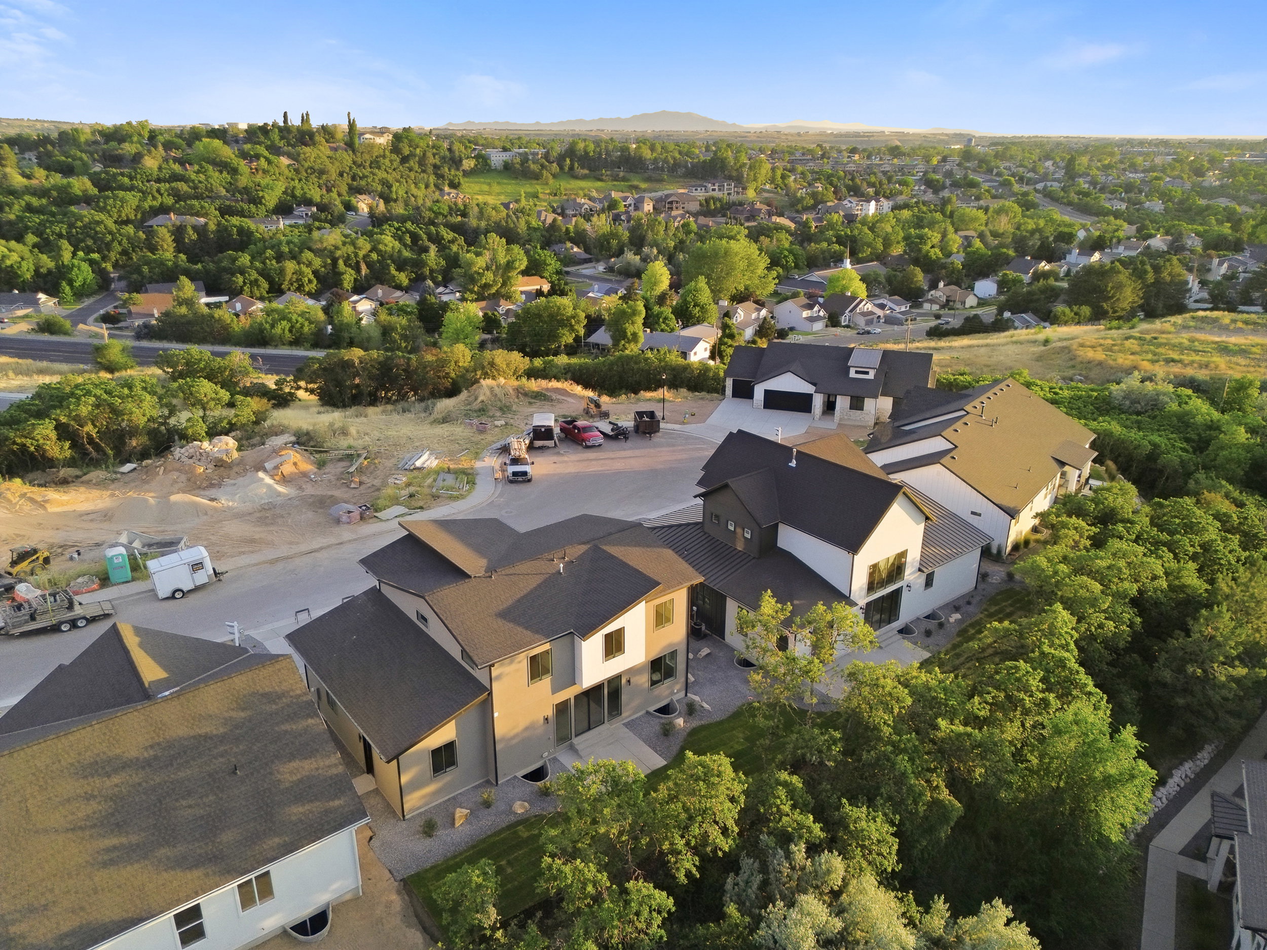 Modern architectural design featuring multi-toned exteriors, expansive windows, and dark-pitched roofs