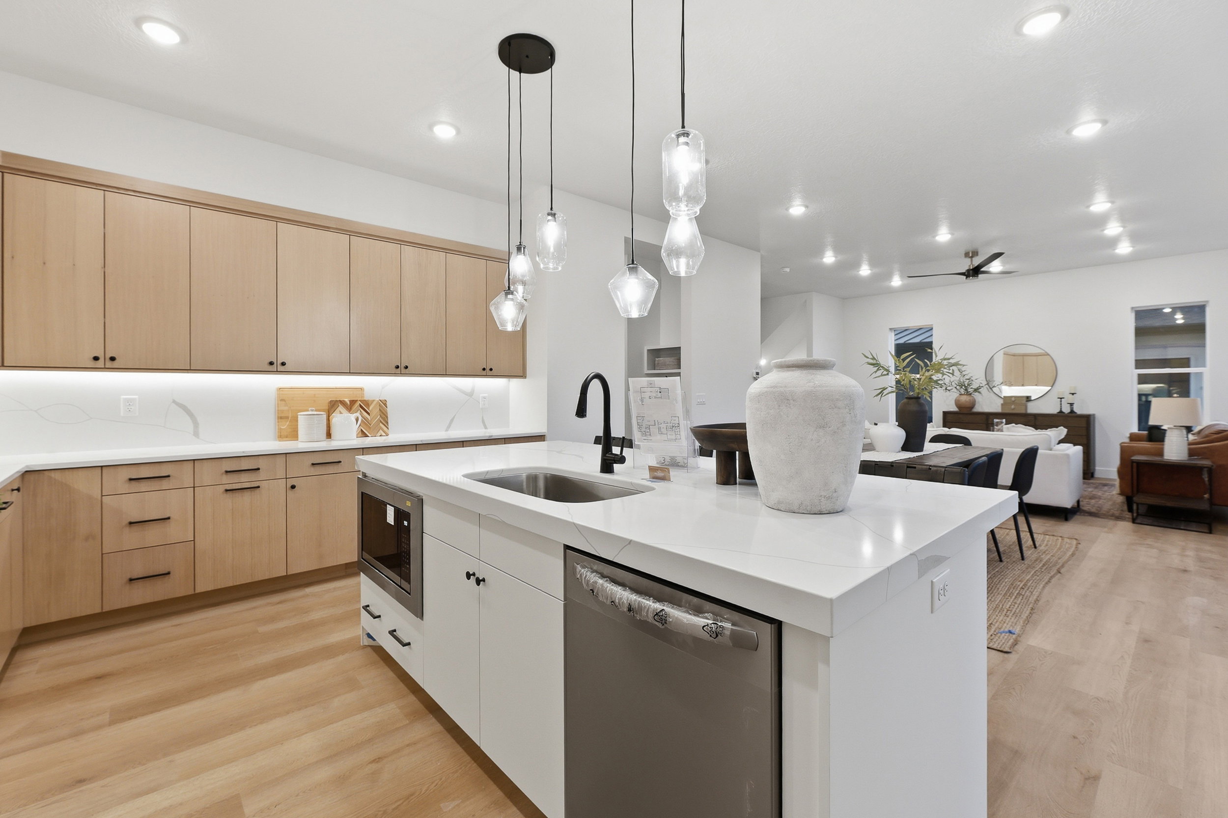 Kitchen island featuring a stainless steel sink with a matte black faucet, integrated microwave, and built-in dishwasher