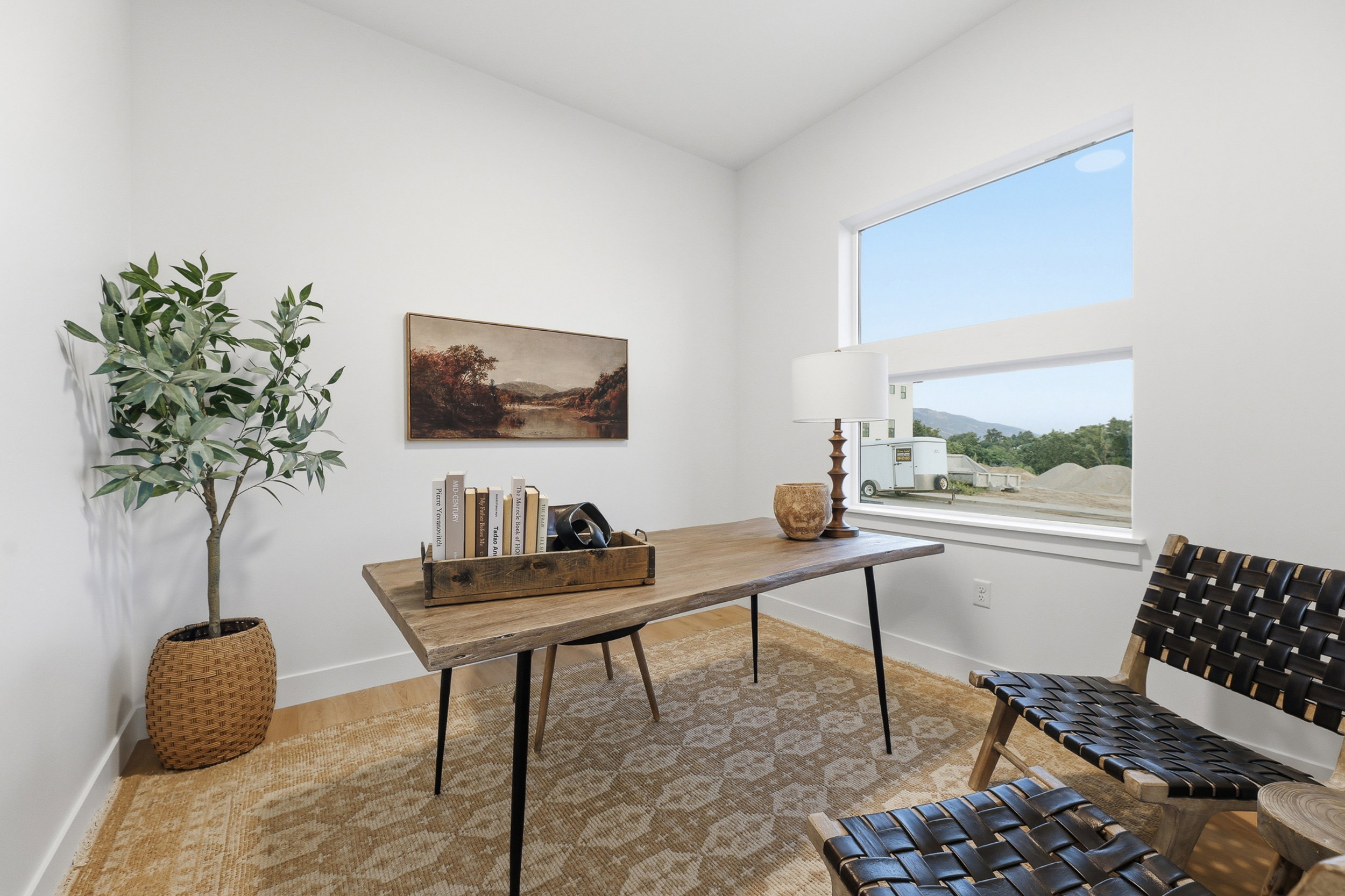Bright room featuring multiple horizontal windows, wood-finish flooring, and white walls