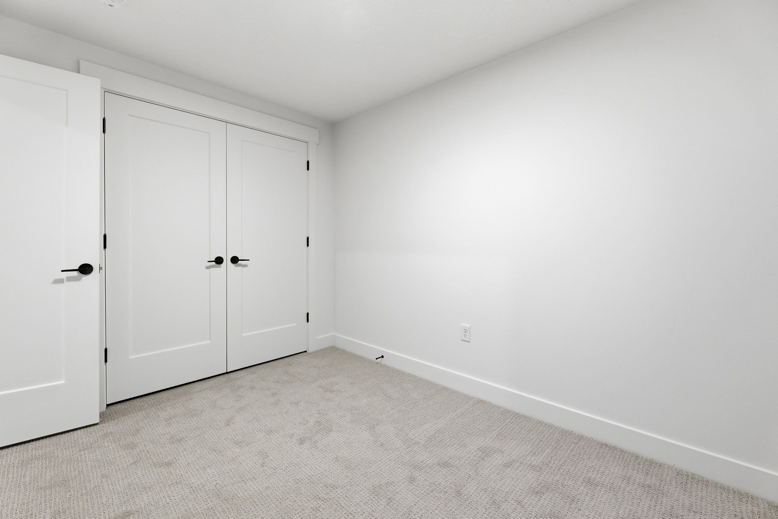 Room with light grey carpet flooring, white walls, and white baseboards