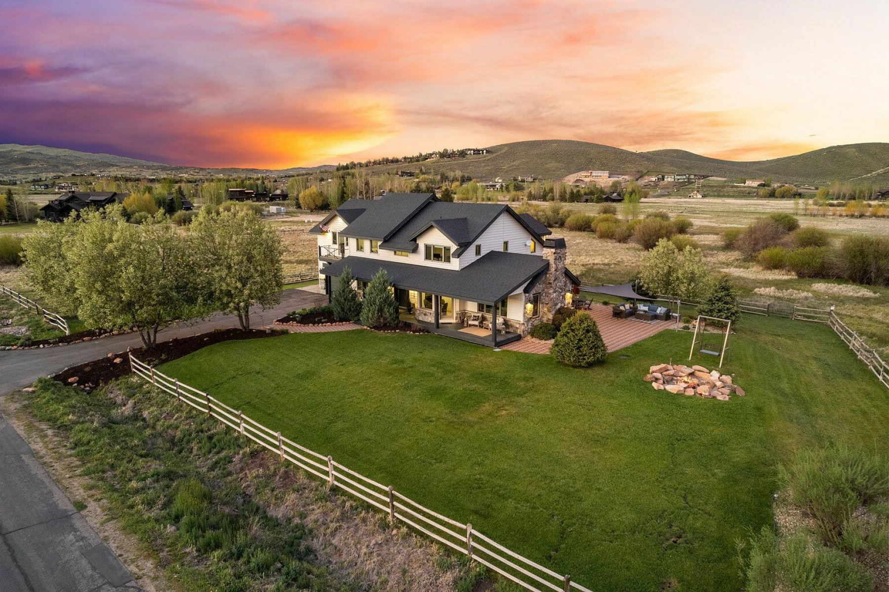 Expansive property featuring a large two-story residence with a covered porch and stone chimney