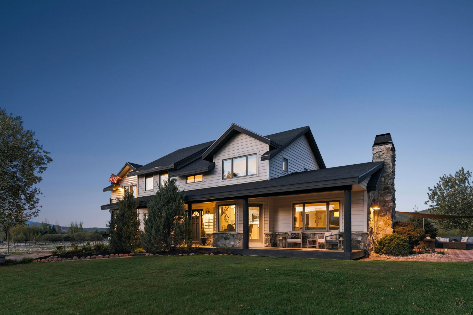 Two-story residence featuring light-colored siding and a dark shingle roof