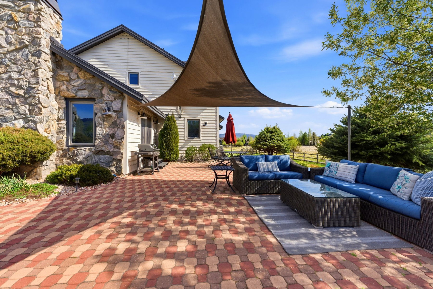 Spacious paver patio with a multi-tone design and shade sail