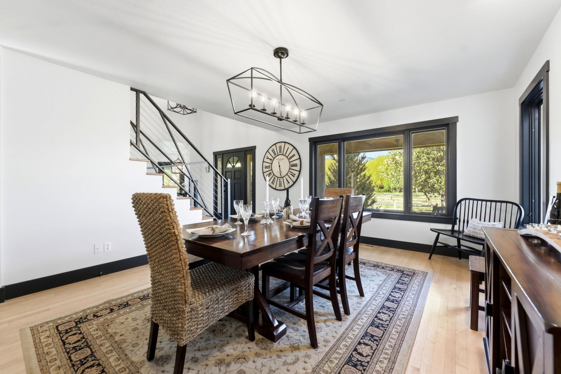 Dining area featuring wood-finish flooring, a dark wood table, and a linear chandelier