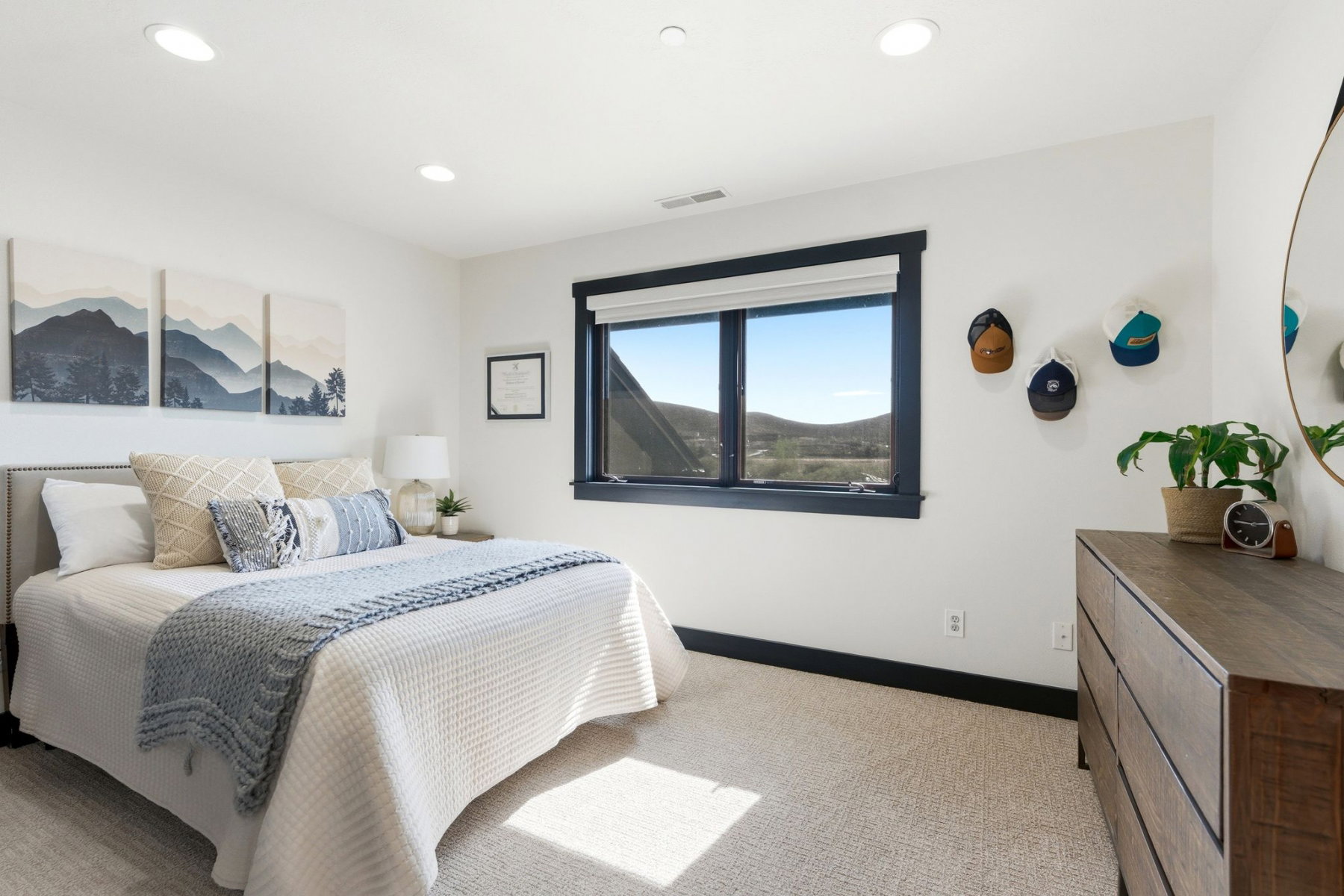 Bedroom featuring a large window with dark trim, recessed ceiling lighting, and light carpet flooring