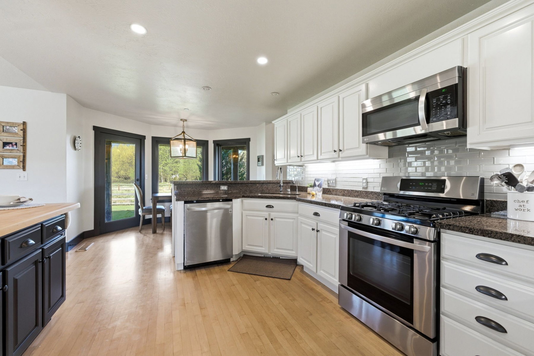 Kitchen featuring stainless steel appliances, white cabinetry, and dark countertops