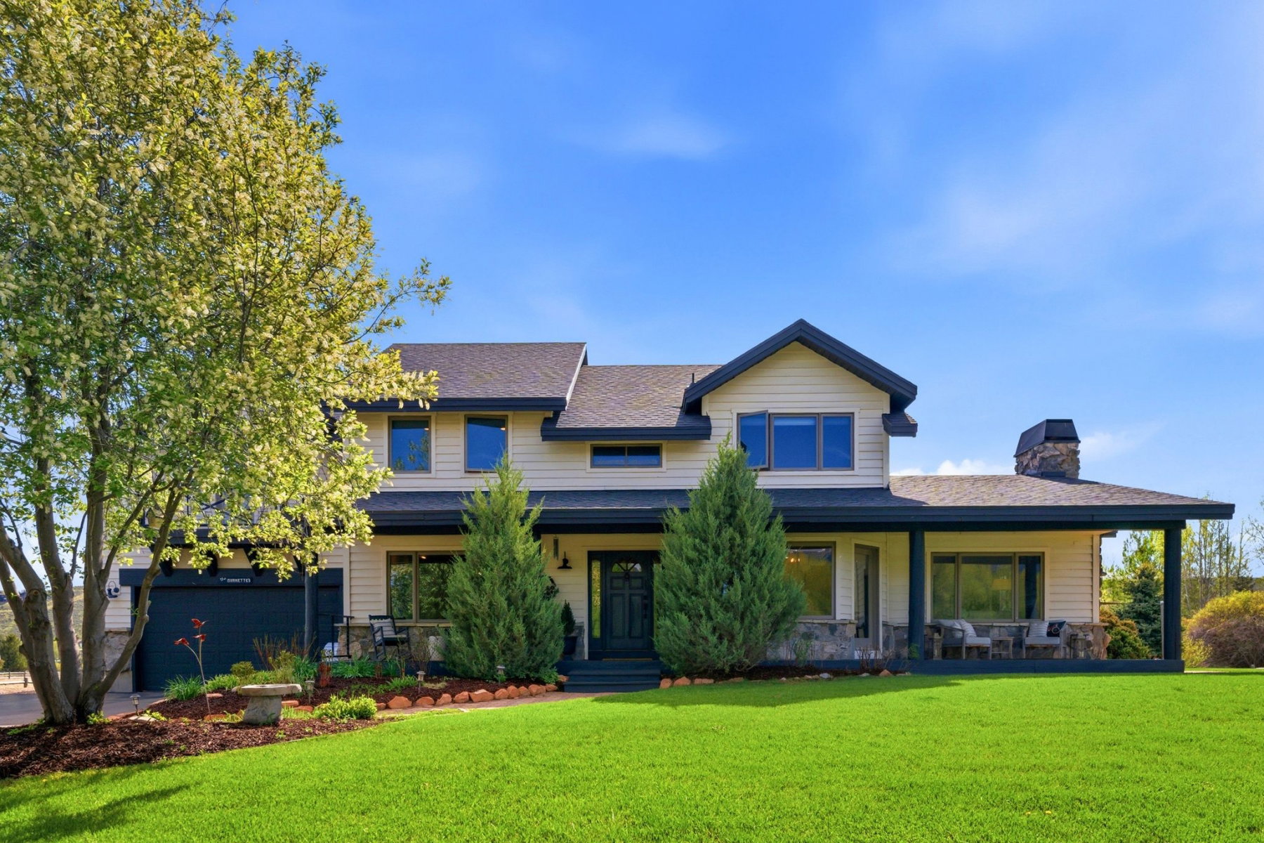 Two-story residence featuring light-colored siding and a dark trim