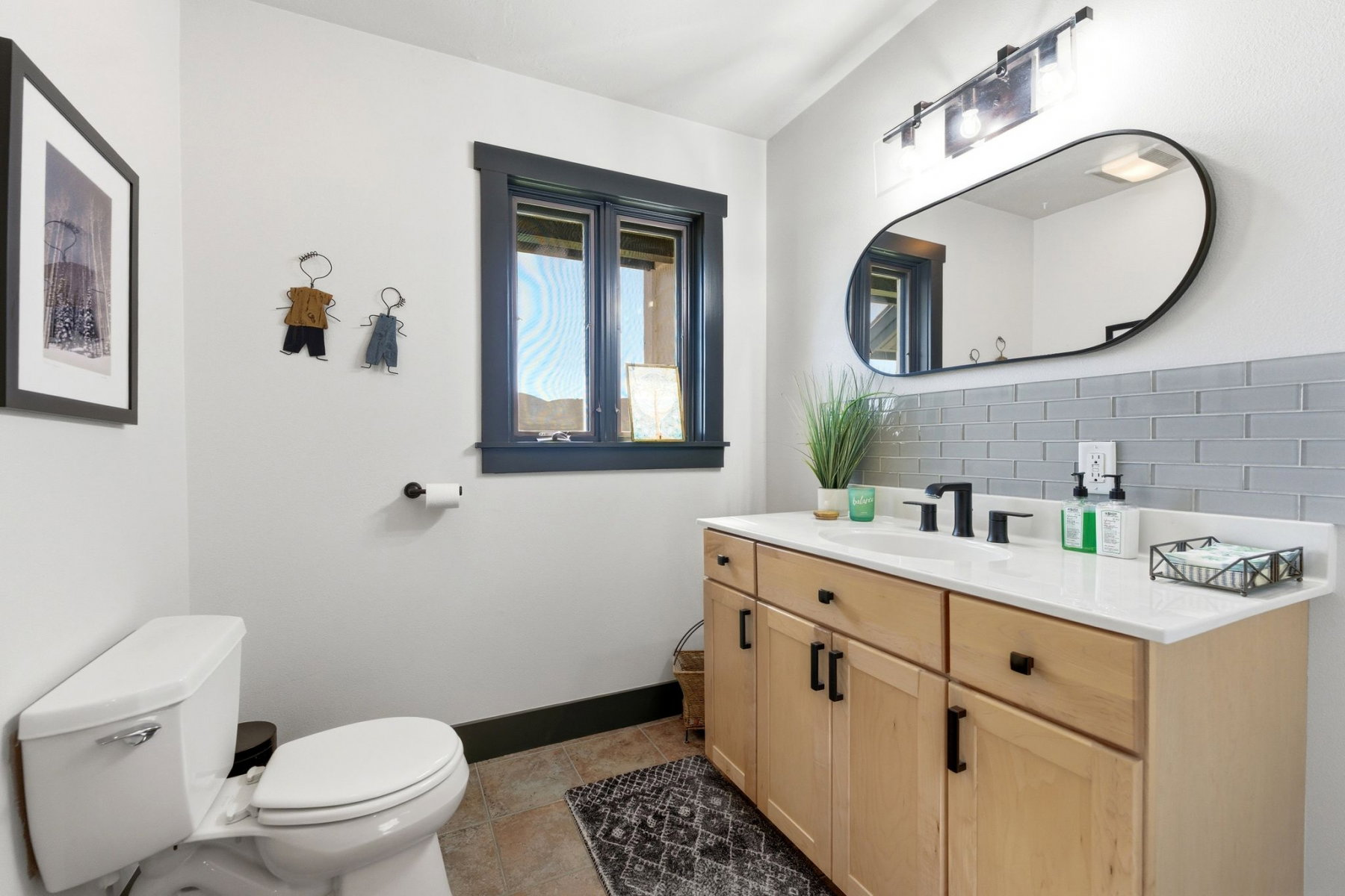 Bathroom featuring a light-finish wood vanity with a white countertop and rectangular sink