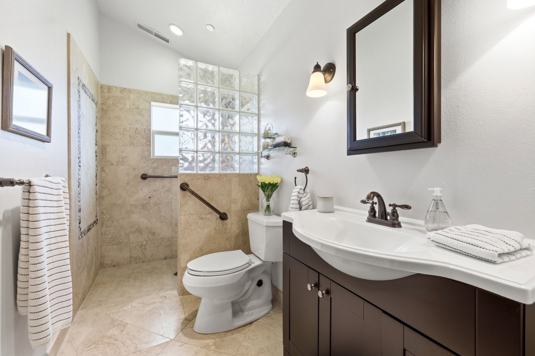 Bathroom featuring a dark wood vanity with an integrated white sink and an oil-rubbed bronze faucet